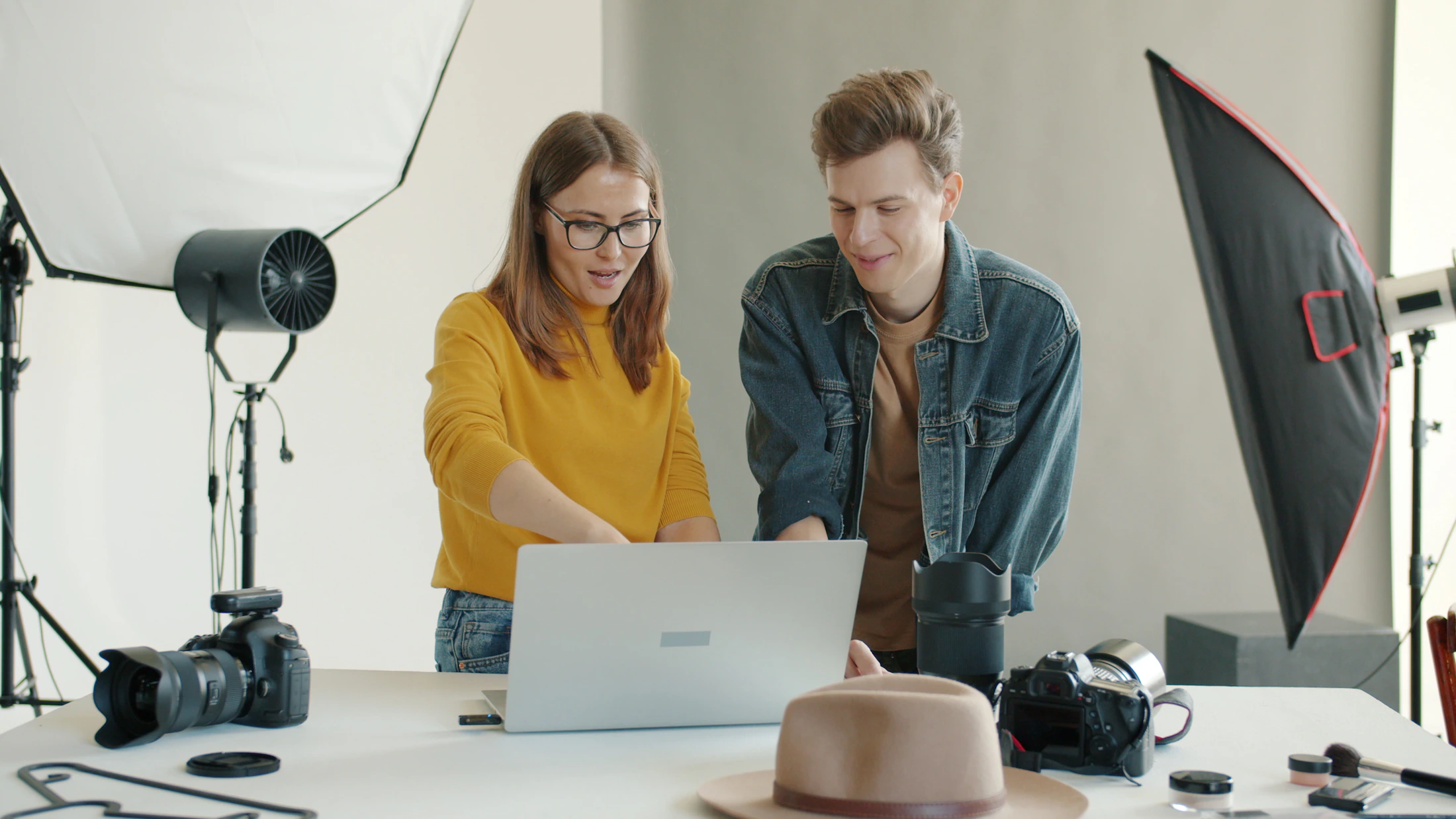 Photographers reviewing images on a laptop in a photo editing and watermark workflow